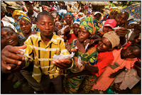 A Congolese village leader checks vouchers before presenting GLCI beneficiaries with cassava seed.