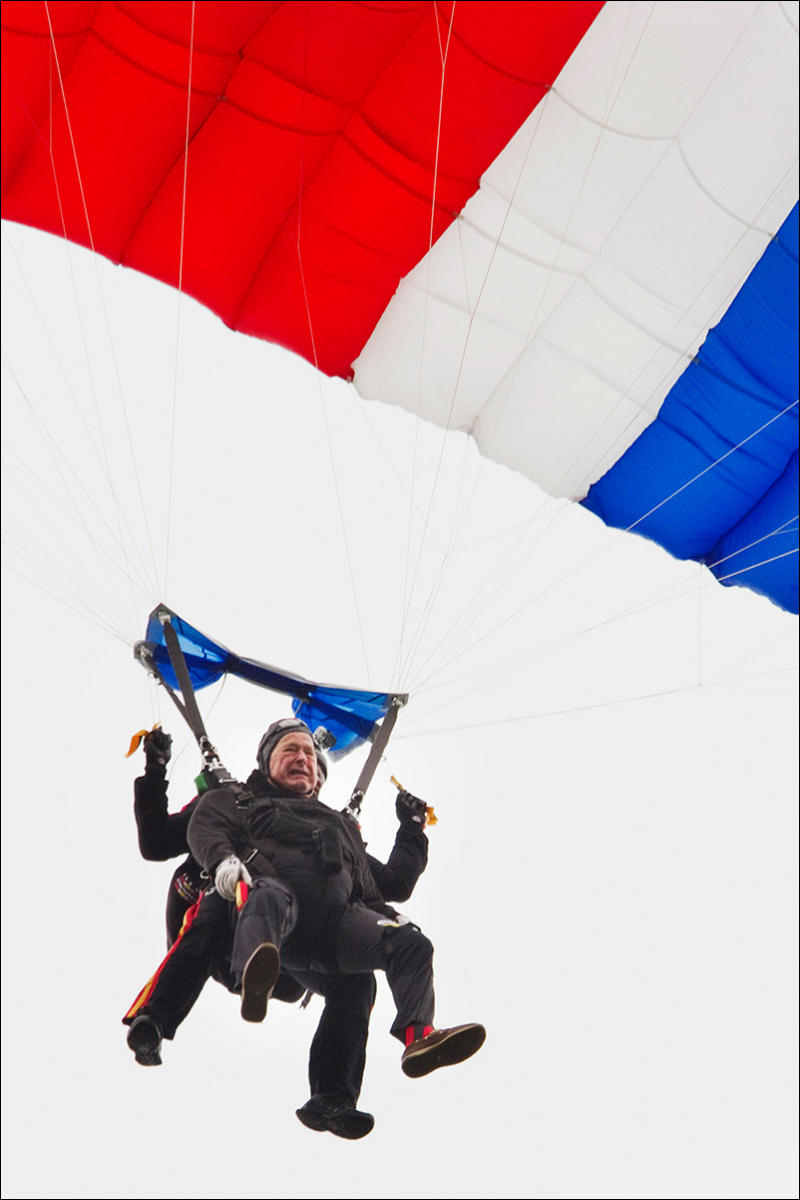 Former President George H. W. Bush rides a tandem skydive to the ground on his 90th birthday.