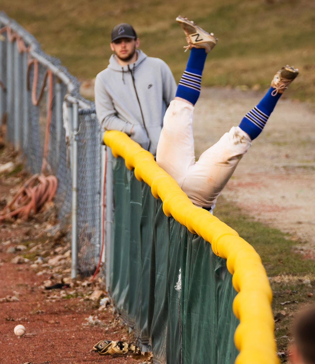 High school girls soccer players compete for ball control at left. A St. Joseph's College outfielder flips over the fence while trying to catch a foul ball.