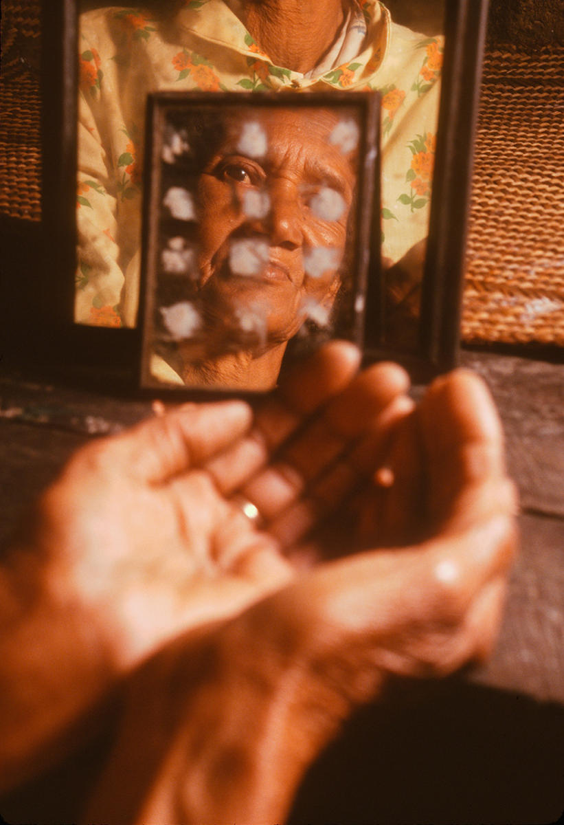 A Malagasy traditional healer looks into a mirror used to communicate with ancestors in the afterlife, to seek their wisdom.