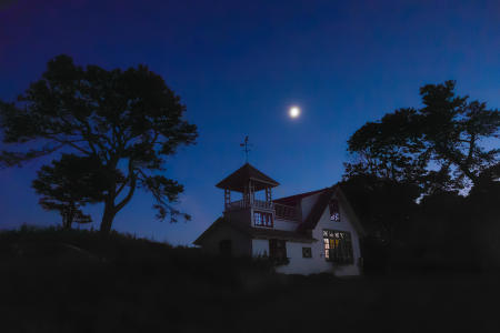 The moon rises behind a Biddeford, Maine coastal property.