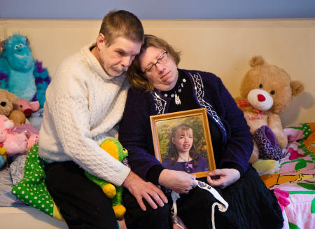Robert and Susan Meehan sit on their daughter Cyndimae's bed, and hold her photo 24 hours after the medical cannabis patient died unexpectedly.