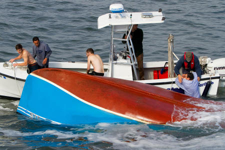 The last of of four capsized fishermen, whose boat overturned in rough surf between the Well Beach and Drakes Island breakwater, is rescued by the Wells Harbor Master crew.
