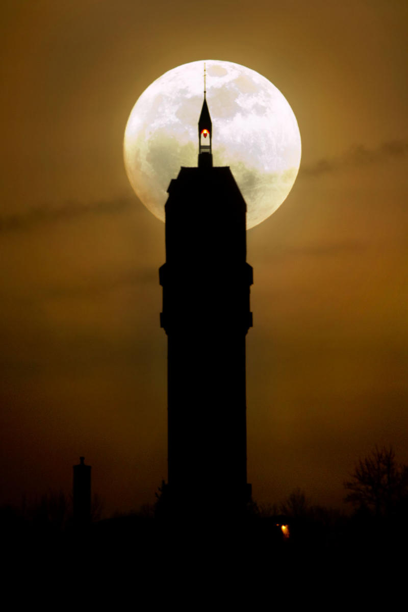 The full moon rises behind Heublein Tower, on Talcott Mountain in Avon, Connecticut.