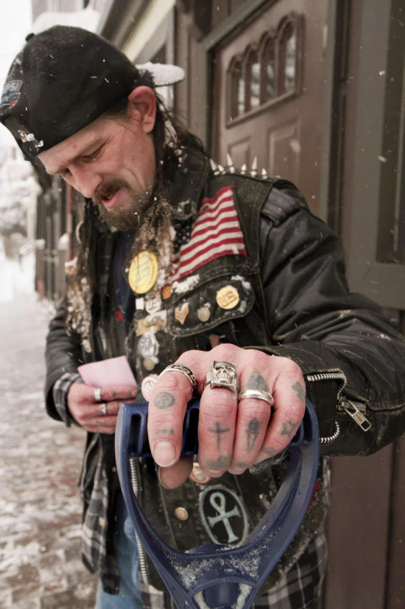 Timothy Fillmore of Cumberland Avenue in Portland checks his work list while clearing snow on several of his landlord's properties during a winter storm.