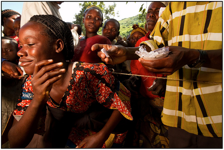 A happy Congolese woman slips beneath the twine to acquire cassava seed.