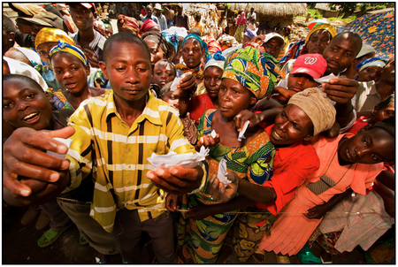 A Congolese village leader checks vouchers before presenting GLCI beneficiaries with cassava seed.