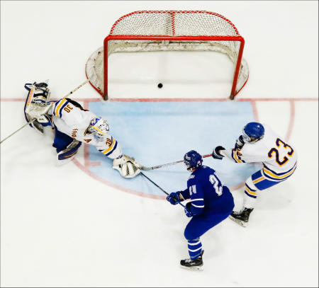 Lewiston's Alex Rivet scores the teams third goal of the second period, against Falmouth goalie Spencer Pierce, defenseman Reece Armitage right, during the Maine Class A State Championship game at the Colisee in Lewiston.