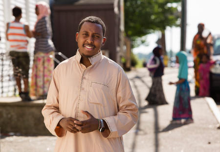 Somali immigrant Osman Bashir, 25, stands in his Lewiston community on Birch Street. Bashir is in the second phase of testing to become a police officer. For the Portland Press Herald.