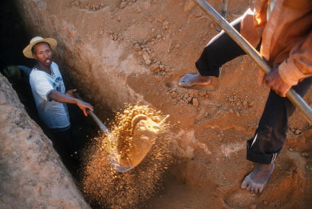 Betsileo villagers dig into the tomb entrance during Famadihana ritual, which includes exhumation and rewrapping of remains in fresh shrouds. Some Malagasy worship the ancestors, believing all will be well in their lives if they honor and remember the ancestors.