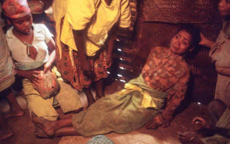 A woman appears to be possessed, during a funeral ritual in which they believe another ancestor is using the living body as a medium, to visit from the afterlife and pay respects to the recently deceased.