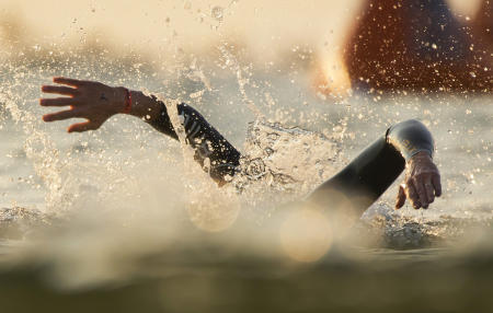 The first two swimmers, of nearly 2000, stroke towards the shore during the first leg of the Ironman Triathlon 70.3 in Old Orchard Beach. Shot for The Portland Press Herald.