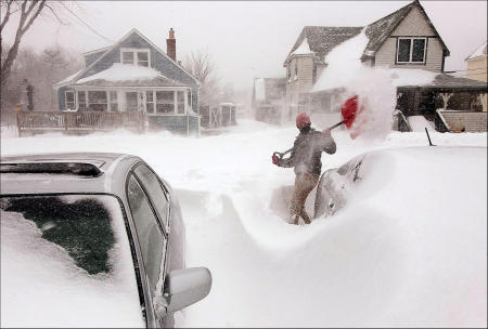 Julia May digs buried cars from the snow in her Ocean Park, Maine driveway during a blizzard which dumped over three feet of snow. Shot for The Portland Press Herald.