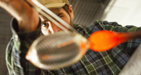 Glass blower Joseph Webster shapes a glass he is creating in his Biddeford, Maine studio. Shot for Portland Press Herald.