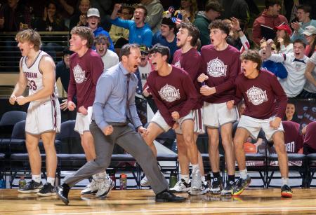 Gorham head coach Ryan Deschenes, team members and fans celebrate a defensive stop assuring victory against Scarborough, in the closing seconds of Class AA South boys basketball championship action in Portland.