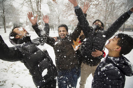 Their first time being in snow, USM freshmen from Nepal, throw it all over each other near the college in Deering Oaks Park.