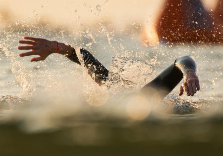 The first two swimmers, of nearly 2000, stroke towards the shore during the first leg of the Ironman Triathlon 70.3 in Old Orchard Beach. 